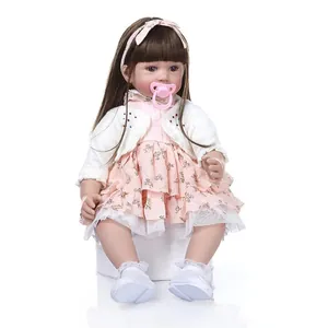 Realistic reborn toddler doll with long brown hair, floral dress and pink pacifier