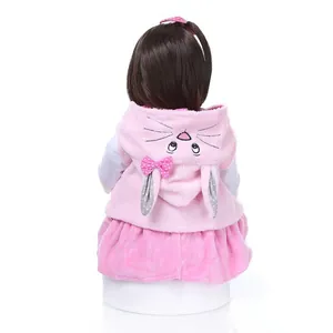 Back view of lifelike reborn toddler doll in pink bunny hooded outfit with long hair