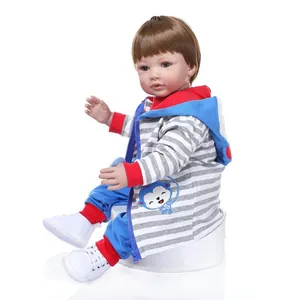 Realistische Reborn Kleinkindpuppe mit braunem Haar und blauem Affen Hoodie Set auf weißem Grund