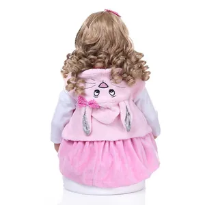Lifelike reborn toddler doll with long wavy hair and a pink bunny hood vest back view