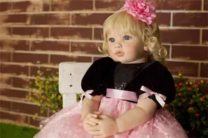Detailed view of reborn toddler doll with blonde curls in pink tulle and black velvet dress