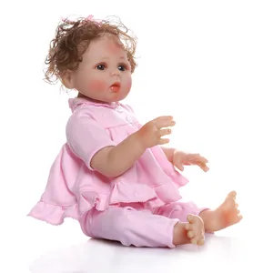 Realistic reborn baby doll with brown curly hair in pink ruffled loungewear outfit