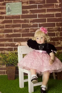 Close-up of 60cm reborn doll with blonde hair and blue eyes in a pink and black princess dress