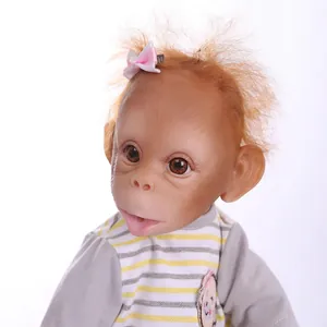 Poupée singe reborn réaliste avec cheveux orange et tenue rayée sur fond blanc
