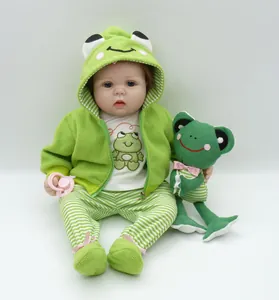Vue détaillée d'une poupée reborn réaliste en tenue de grenouille avec peluche assortie