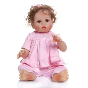 Realistic reborn baby doll with brown curly hair and pink outfit on a white background