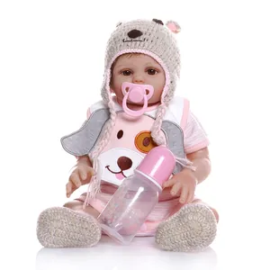 Detailed close-up of a lifelike reborn baby doll in pink striped outfit and knitted bear hat