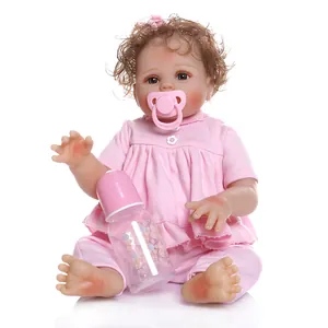 Realistic reborn baby girl doll with brown curly hair and pink dress including milk bottle