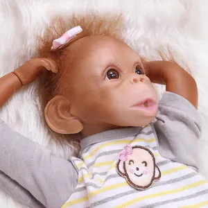 Poupée singe reborn réaliste avec cheveux orange et grenouillère rayée sur fourrure