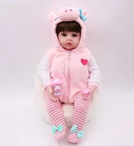Close-up of a lifelike reborn baby doll in a pink pig outfit with a bottle and pacifier