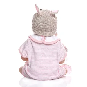 Close-up of baby doll wearing pink striped romper and crochet hat with cute ears