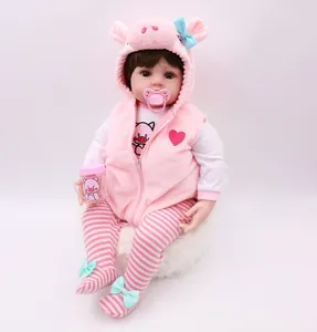 Detailed view of reborn baby doll with pink piglet hoodie, pacifier and bottle
