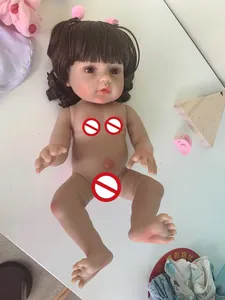 Close-up of realistic newborn doll with brown curly hair and pink pacifier details
