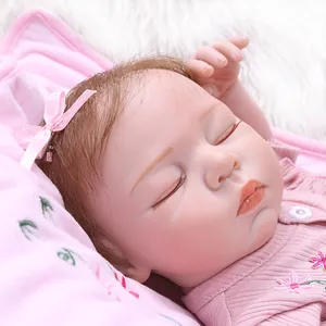 Close-up of sleeping reborn doll face with hand-painted details and pink bow