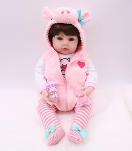 Realistic reborn baby doll in pink pig outfit with feeding bottle and pacifier accessory