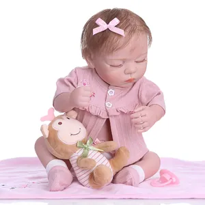 Detailed set of realistic reborn baby doll with plush monkey and pink accessories