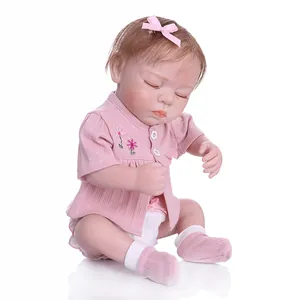 Detailed view of sleeping reborn doll face with realistic skin and pink floral outfit