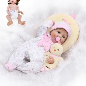 Poupée réaliste nouveau-né avec boucles brunes, tenue florale rose et canard en peluche