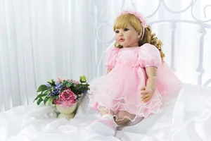 Dettaglio di una bambola reborn da 60cm con capelli biondi ricci e fascia con fiori rosa