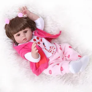 Realistic reborn baby doll in pink hoodie and giraffe print set on white plush rug