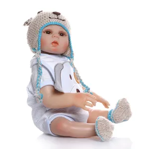 Detail view of a lifelike reborn baby doll wearing a knitted hat and puppy patterned outfit