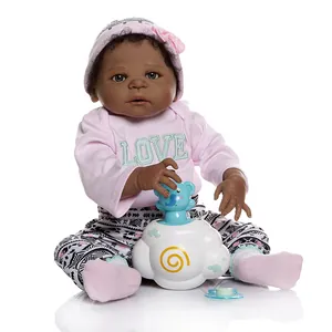 Poupée bébé reborn réaliste avec peau foncée et tenue rose sur fond blanc