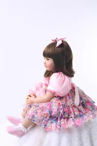 Détail d'une poupée princesse reborn de 60cm en robe rose sur un tapis en peluche