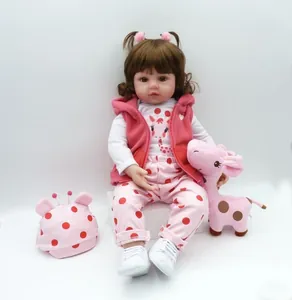 Detailed view of reborn baby doll with pink vest and plush giraffe toy accessory