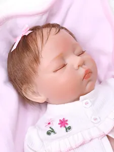 Close-up of sleeping reborn baby doll with delicate eyelashes and pink bow headband