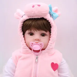 Realistic reborn baby doll in pink plush pig vest with a matching pacifier