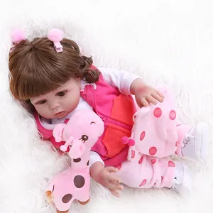 Detailed view of reborn baby doll with brown curls and pink giraffe plush toy