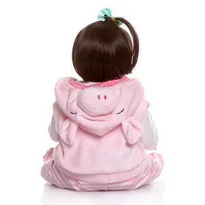 Lifelike 47cm full silicone baby doll with pink pig-themed outfit and soft brown hair