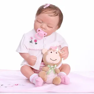 Close-up of realistic sleeping baby doll with pink pacifier and brown monkey plush toy