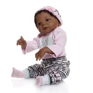 Poupée bébé reborn réaliste noire portant un pull rose et un pantalon à motifs géométriques