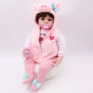 Realistic reborn baby doll in pink pig outfit with matching bottle and pacifier accessories