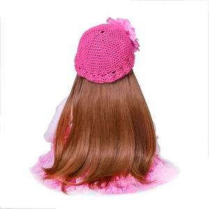 Realistic reborn toddler doll with long brown hair and pink crochet flower hat back view