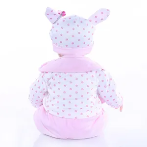 Rear view of lifelike soft silicone baby doll wearing pink polka dot outfit with bunny hat