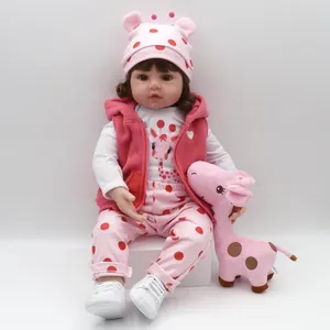 Realistic reborn baby doll in pink polka dot outfit with a giraffe plush toy