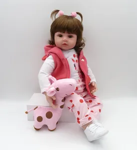 Detail of 47cm reborn baby doll wearing a pink vest and giraffe tee with plush toy