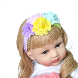 60cm reborn doll wearing a colorful floral headband with purple lace and bright fabric flowers