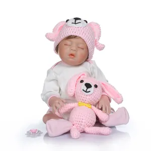 Bambola Reborn realistica che dorme con cappello rosa e giocattolo a forma di coniglio