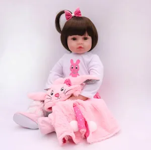 Lifelike 47cm silicone reborn baby doll with brown hair, pink bow and plush rabbit toy
