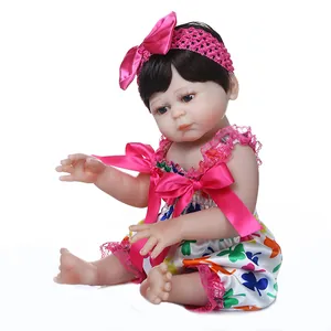 Realistische 48cm Reborn Puppe im Kleeblatt Kleid mit rosa Spitzen Haarband im Sitzen