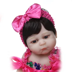 Lebensechte 48cm Reborn Puppe mit rosa Spitzenoutfit und Satinschleife vor weißem Grund