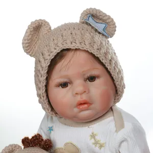 Dettaglio di bambola reborn in silicone con lunghe ciglia e cappello con orecchie da orso