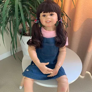 Detail of life-size 98cm realistic jointed doll wearing a pink shirt and denim dress