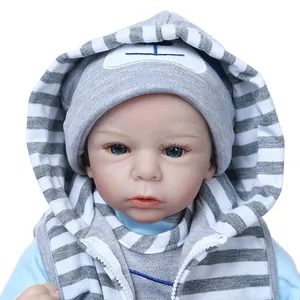 Realistic reborn baby doll with blue eyes and gray striped hooded vest on white background