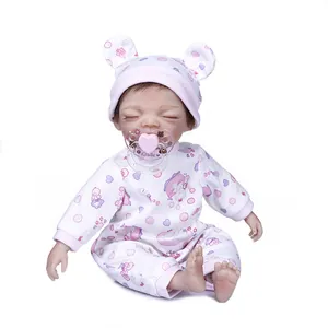 Close-up of 30cm sleeping reborn baby doll in floral romper with pink magnetic pacifier
