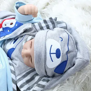Lifelike reborn baby doll in blue striped hoodie sleeping on white plush rug