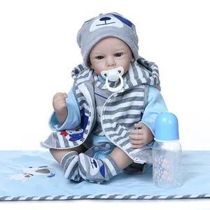 Realistic reborn baby doll in blue striped outfit with pacifier and nursing bottle
